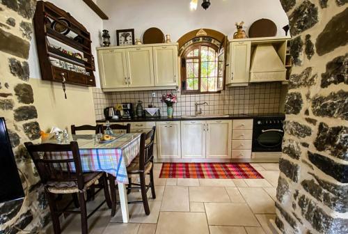 a kitchen with a table and chairs in a room at Villa Fragk in Nipiditos village in Arkalochori