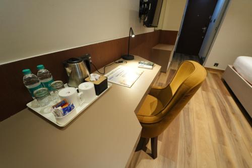 a room with a desk with a chair and water bottles at Vaishnavi Residency in Bengaluru