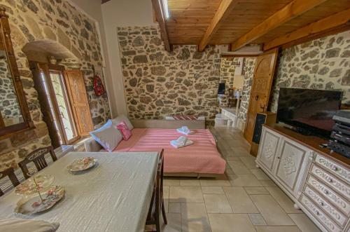 a room with a bed and a table and a tv at Villa Fragk in Nipiditos village in Arkalochori