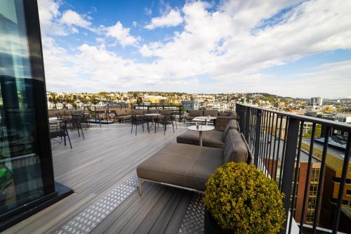 a balcony with a couch and tables and chairs at Clarion Hotel The Edge in Tromsø