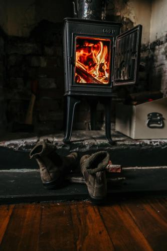 a pair of shoes in front of a fireplace at Two Brothers' Cabin in Deeside