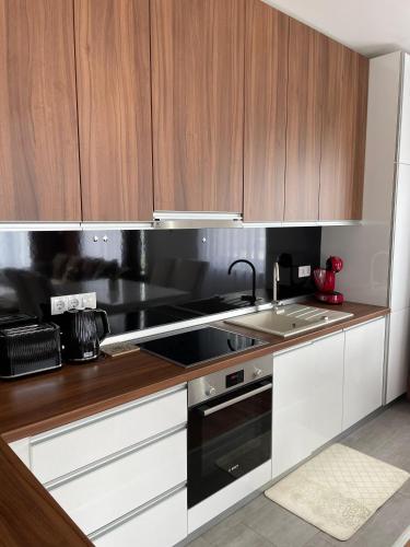 a kitchen with wooden cabinets and a sink and a stove at pazaric residence in Doljani