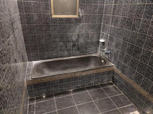 a bathroom with a bath tub in a tiled floor at AL Fateh Hotel in Lahore
