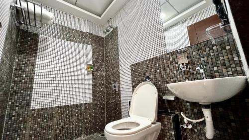 a bathroom with a toilet and a sink at Dojo Inn in Karmād