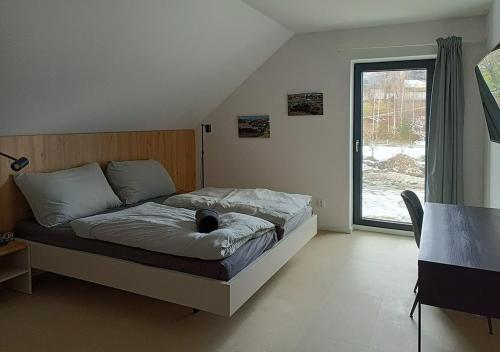 a bedroom with a bed and a large window at Wellness Chalupy LETOKRUHY in Jeseník
