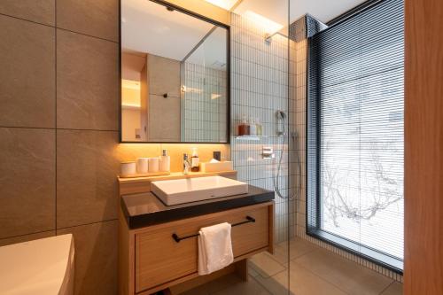a bathroom with a sink and a mirror at Niseko Kyo in Kutchan