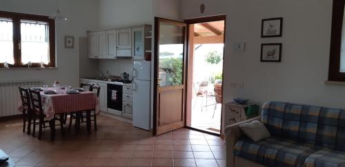 a kitchen and dining room with a table and a couch at Bio Agriturismo Le Giunchiglie in Alberese