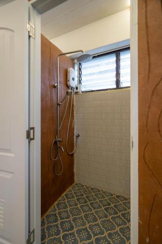 a bathroom with a shower with a shower curtain at Puprai Tarnnarm Resort in Thong Pha Phum