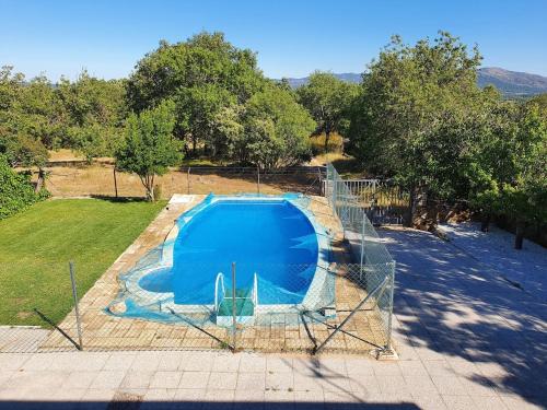a metal fence around a blue swimming pool at El Robledo II in Becerril de la Sierra