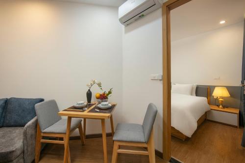 a room with a bed and a table and chairs at Westlake Pearl Apartment - Hotel & Pearl Spa in Hanoi