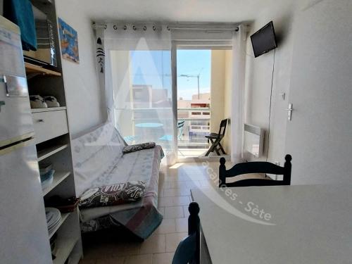 une chambre avec un lit et une fenêtre avec vue dans l'établissement Coquet T2 avec balcon en plein coeur du quartier de la Corniche proche commerces et plages, à Sète