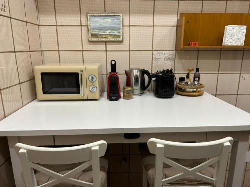 a kitchen counter with a microwave and two chairs at Colosseum's Custodian - Apartment 115 m2 in Rome