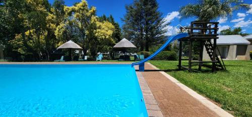 BonjaneniにあるMont Aux Sources Drakensberg Resortの青いプール(滑り台付)、遊び場