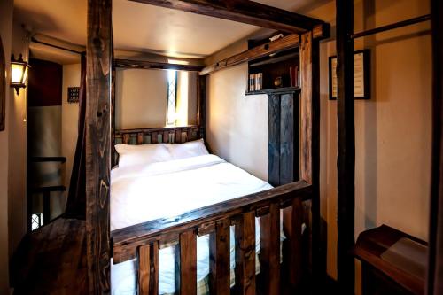 a bed in a wooden frame in a room at Entire Castle & Grounds for 18, Banquet Hall & BBQ in Trowbridge