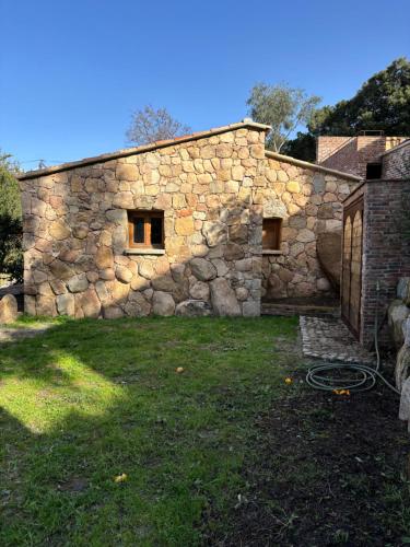a stone building with a stone wall at Bergerie CASEDDU U CHJASSU in Viggianello