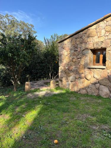 a stone building with a window in a yard at Bergerie CASEDDU U CHJASSU in Viggianello