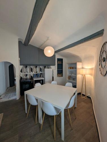 a kitchen and dining room with a white table and chairs at Les Toits d'Allauch in Allauch