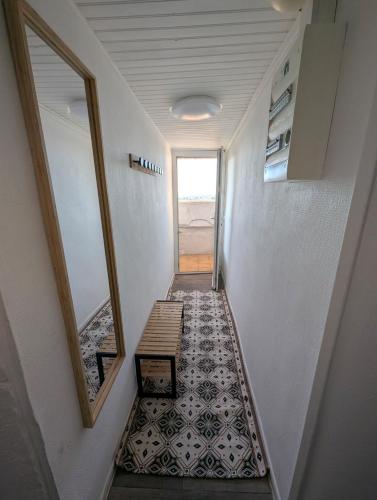 a hallway with a staircase with a mirror and a tile floor at Les Toits d'Allauch in Allauch
