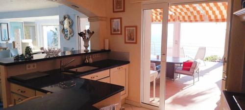 une cuisine avec un évier et un salon dans l'établissement Le coin de paradis, à Saint-Raphaël