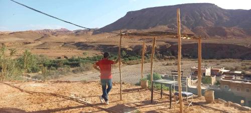 a man is standing on a frame in the desert at Tigmi Hamid Découverte des traditions et de la culture berbère in Aït Ben Haddou