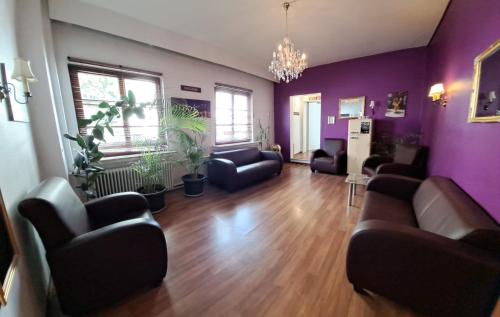 a living room with purple walls and couches at Hotel Columbus und Glamping in Bremerhaven