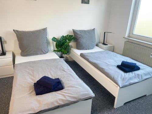 2 Betten in einem Zimmer mit blauen Kissen darauf in der Unterkunft bookandstay24 Dietzenbach 2 Zimmerwohnung mit Balkon, Küche und Parkplatz-14 in Dietzenbach