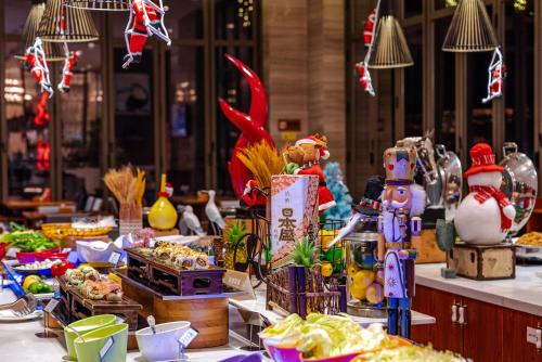 a buffet of food with figurines on a table at Sanya Dadonghai Seaview Hotel in Sanya