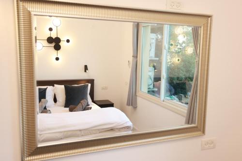 a bedroom with a bed and a large mirror at הבית ליד הבוסתן in Mikhmannim