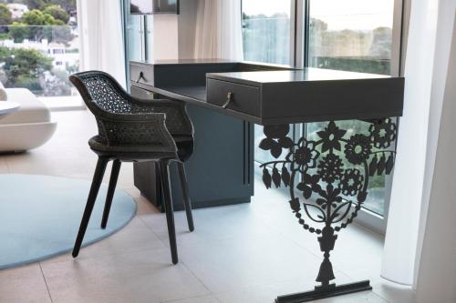 a black desk with a chair in a room with a window at The Donna Portals in Portals Nous