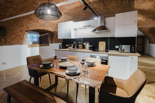 una cucina con tavolo e sedie in legno di Ziegelloft Appartements - Altstadtnah und direkt an der Ilz a Passavia