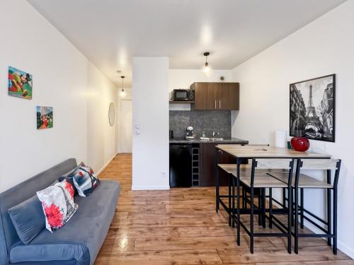 un salon avec un canapé et une table dans l'établissement Cosy Studio Disneyland Paris - Rentaway BnB, à Montévrain