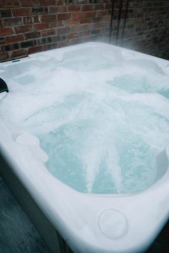 a bath tub covered in snow next to a brick wall at Stunning Town Centre Apartments with Spa facilities in Morpeth