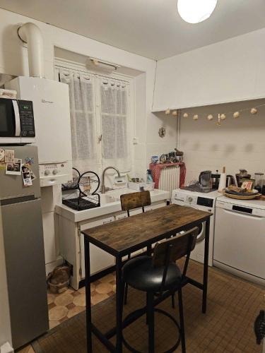 - une cuisine avec une table et 2 chaises dans l'établissement Charming and cosy apartment, à Paris