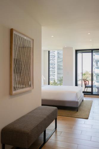 a bedroom with a bed and a bench in it at Crisol Suites Condesa in Mexico City
