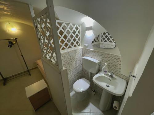a small bathroom with a toilet and a sink at La casa sotto il castello! in Carovigno