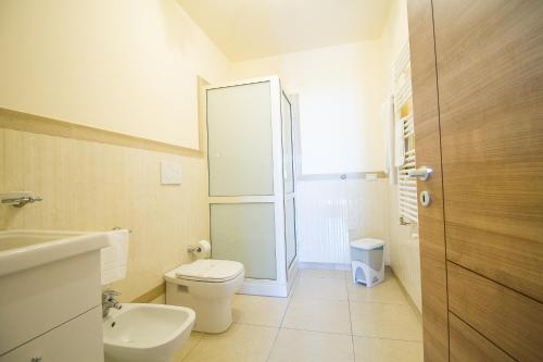 a white bathroom with a toilet and a sink at Etna Royal View in Trecastagni