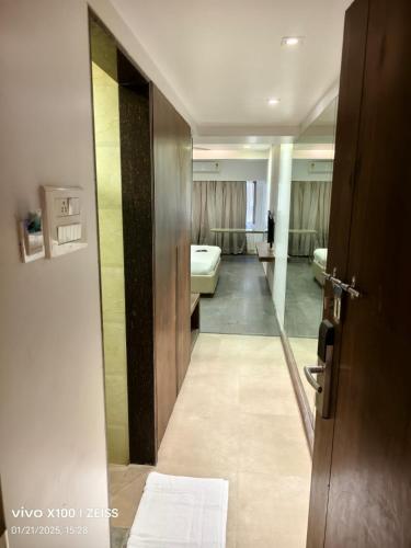a view of a bathroom with a mirror and a door at Hotel Dakshin Grandeur in Navi Mumbai