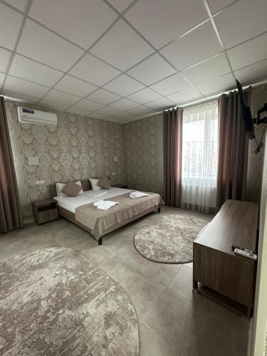 a bedroom with a bed and two rugs at Motel Xameleon in Voznesensk