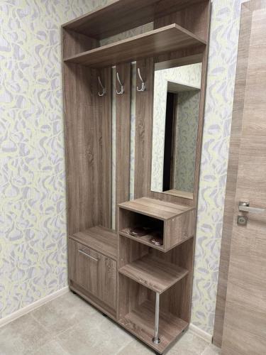 a wooden cabinet with a mirror in a bathroom at Motel Xameleon in Voznesensk