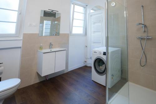 La salle de bains est pourvue d'un lave-linge et de toilettes. dans l'établissement Grand appartement spacieux, à Strasbourg
