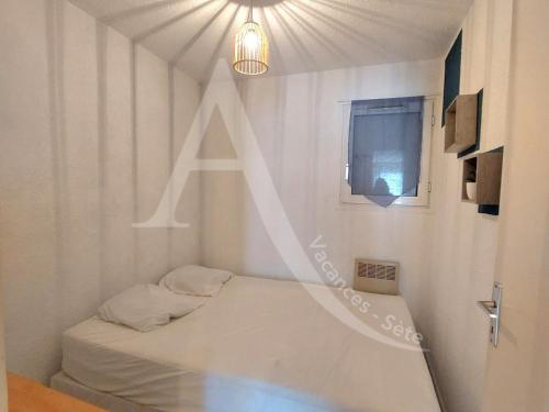 Cette chambre comprend un lit avec une lettre sur le mur. dans l'établissement T3 en plein coeur Corniche et proche des plages, à Sète