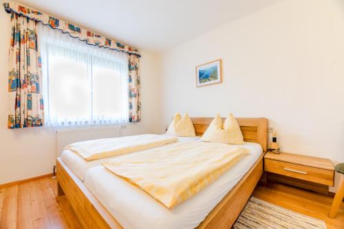 a bedroom with a large bed and a window at Sonnhof in Villach