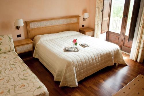 a bedroom with a bed with a tray of flowers on it at La Rosa Nel Bicchiere in Soveria Mannelli