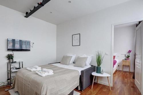 une chambre blanche avec un lit et une table dans l'établissement Bluestay 650 - Superb apartment in Paris, à Paris
