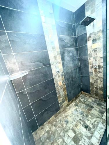 a bathroom with a shower with a glass door at 2 bedroom Coastal Appartment 50 m walk to the beach in Bain Boeuf