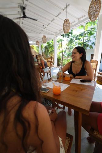 a woman sitting at a table in a restaurant at MAKAI Surf House in Ahangama