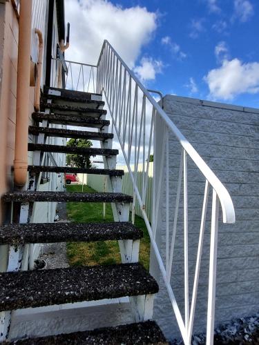 a staircase with a white railing next to a building at Cedar Lodge Motel Hamilton in Hamilton