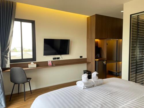 a bedroom with a bed and a tv on the wall at The Richer Ratchaburi in Ratchaburi