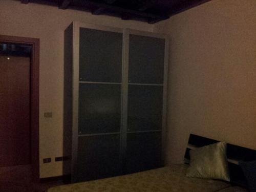a bedroom with a large glass closet in the wall at San polo house in Parma