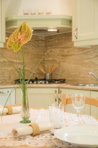 a table with a vase with a yellow flower on it at Apartments Beni in Matulji